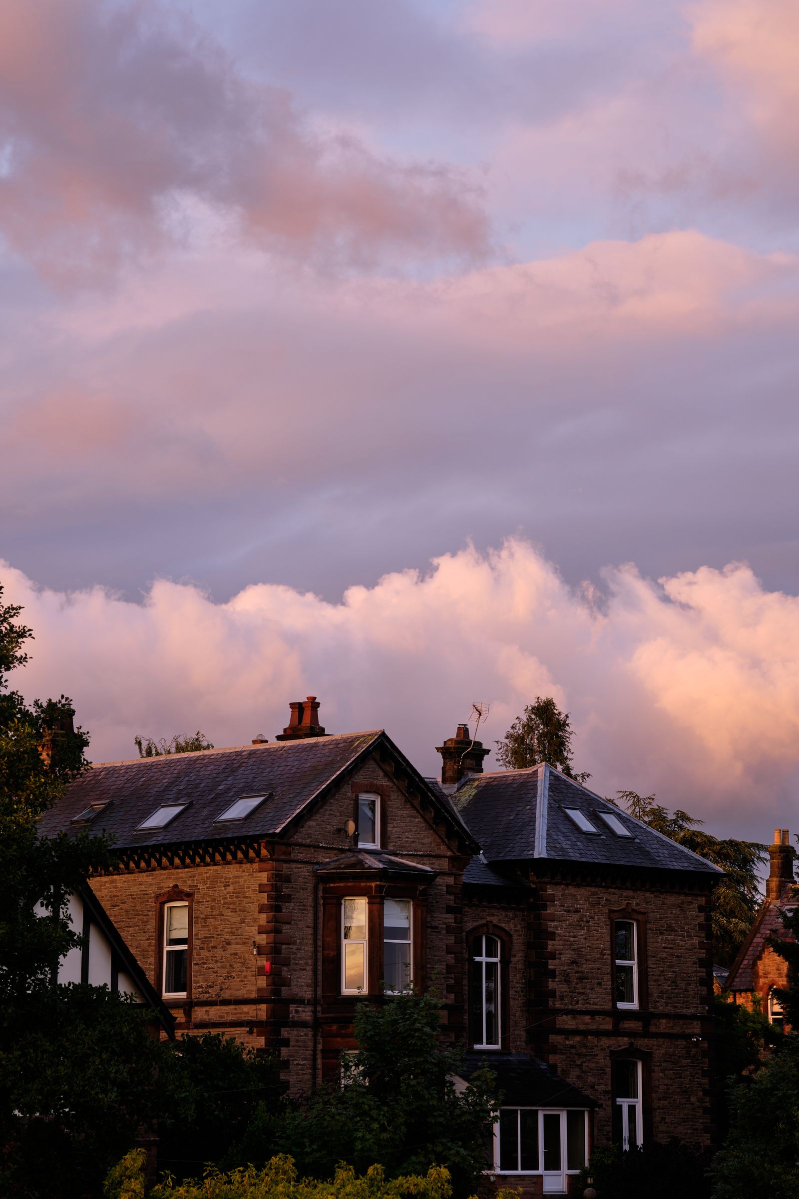 Traditional brick home at dusk with warm light through the windows