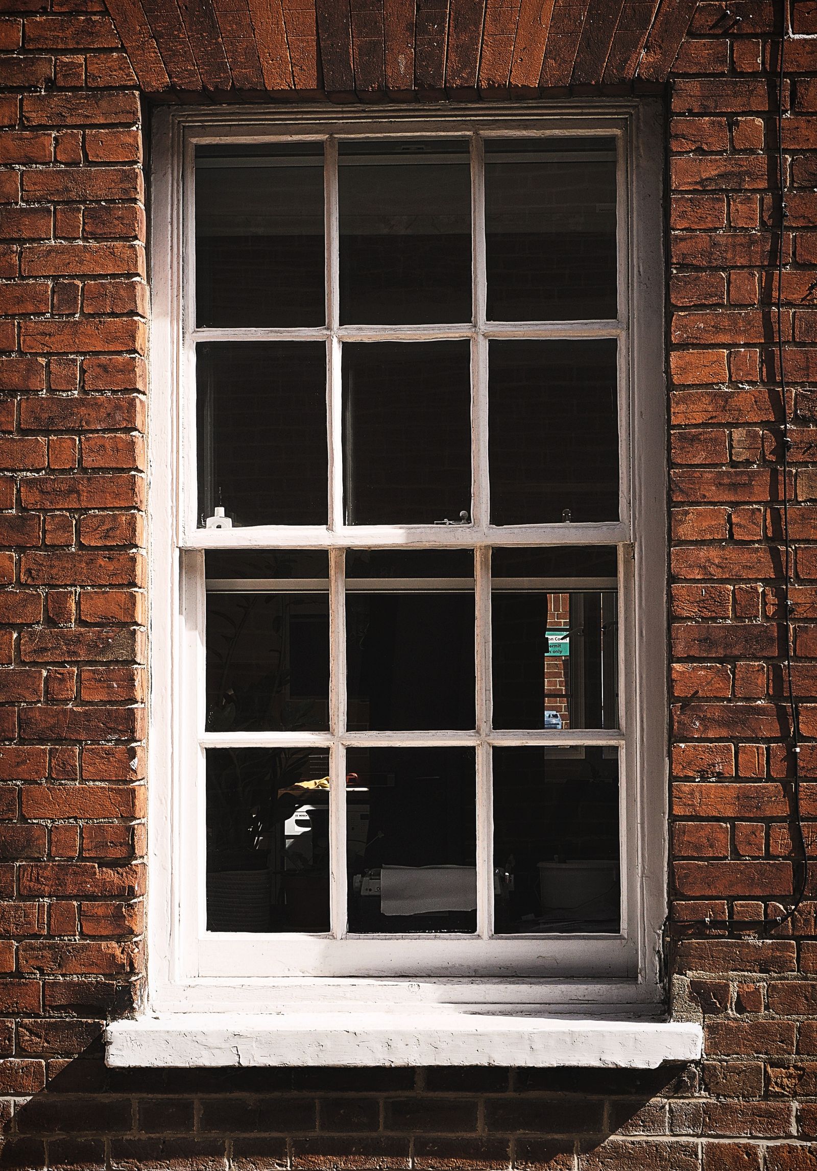 Classic white sash window set in a red brick wall