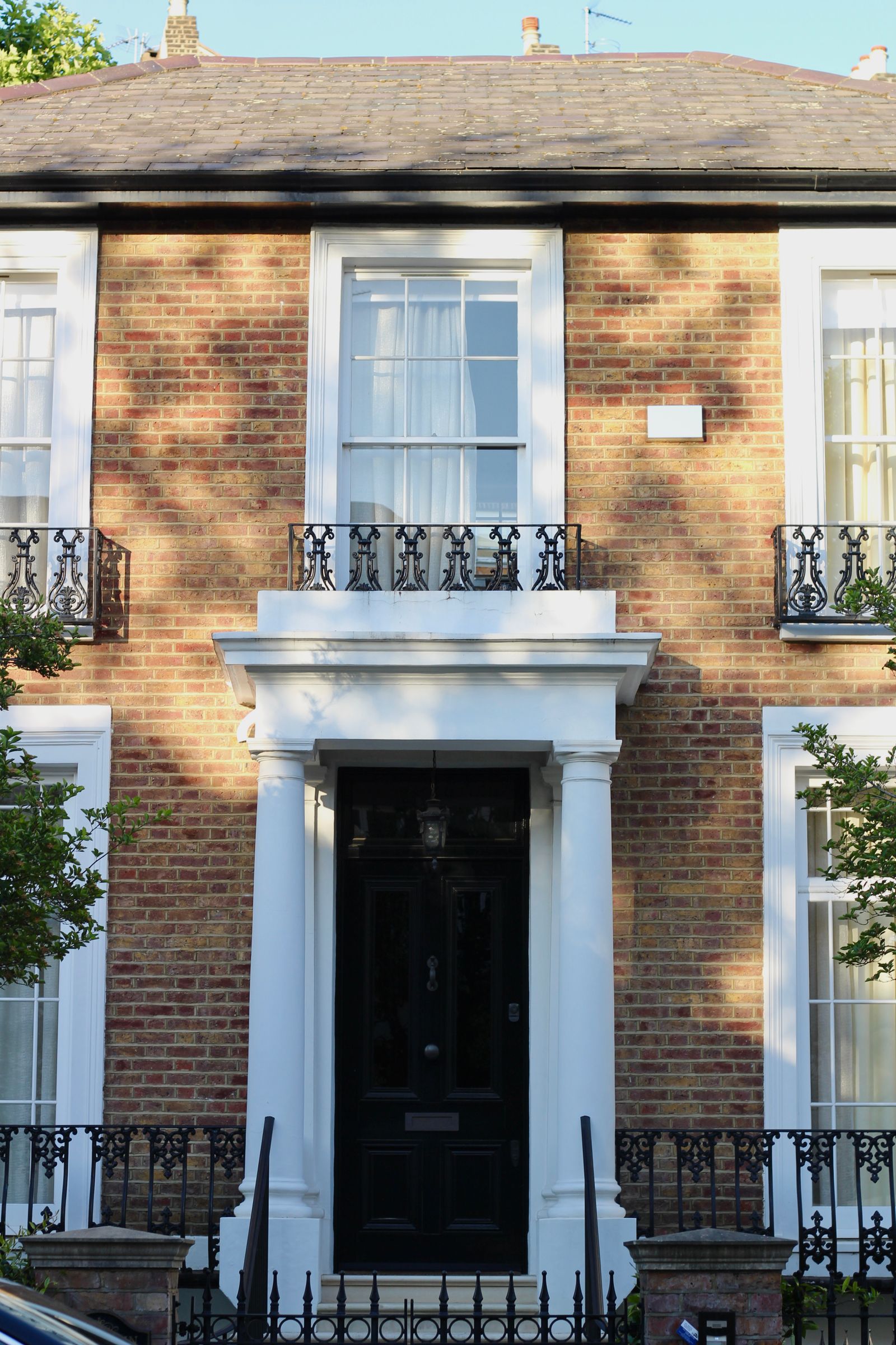 Classic brick home with white sash windows and a smart black front door
